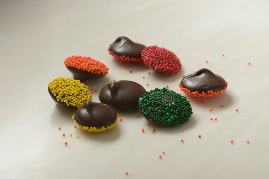 Handcrafted dark chocolate nonpareils adorned with colorful seeds