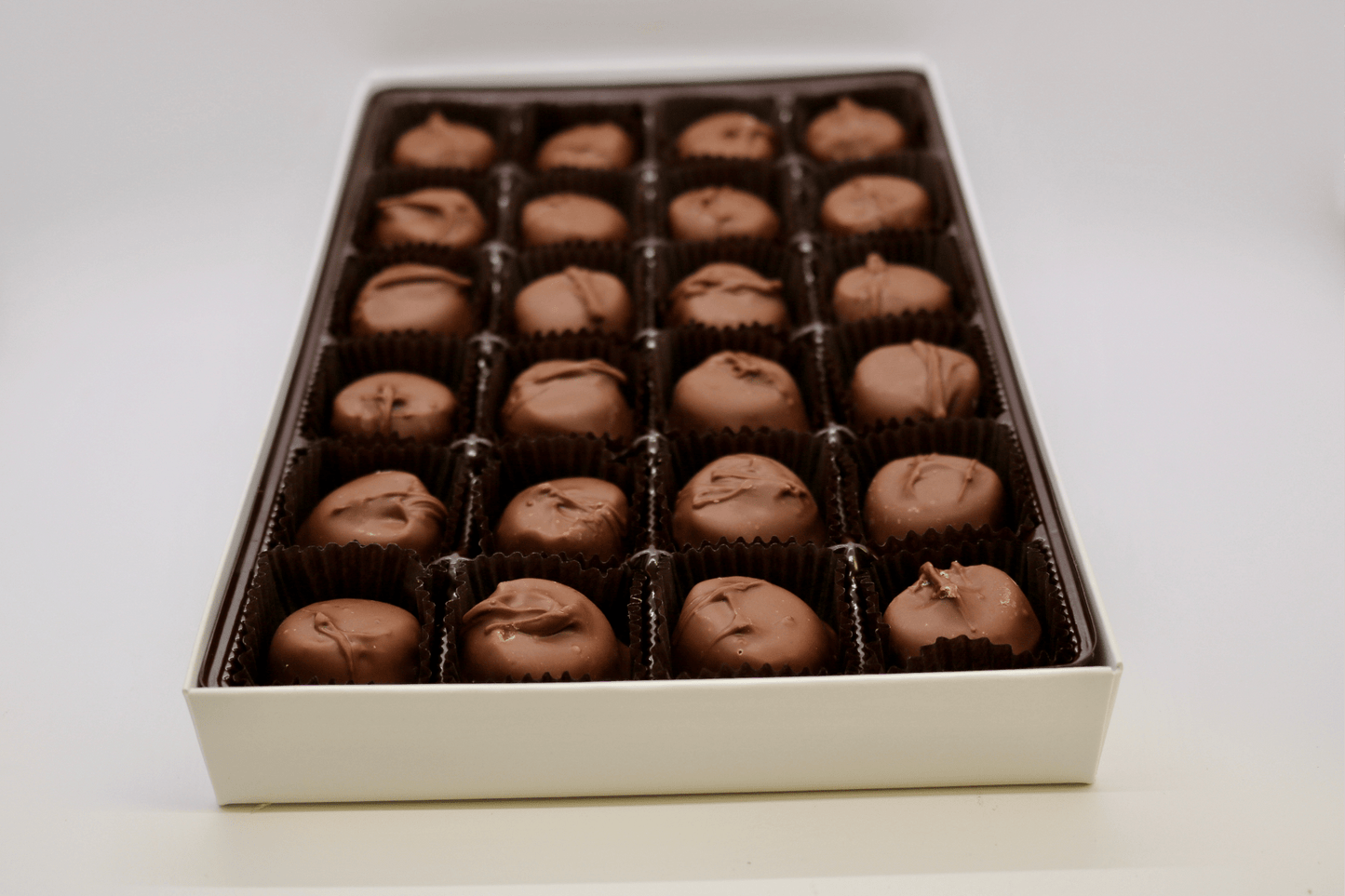 Close-up of handmade milk chocolate vanilla buttercreams with creamy vanilla centers.