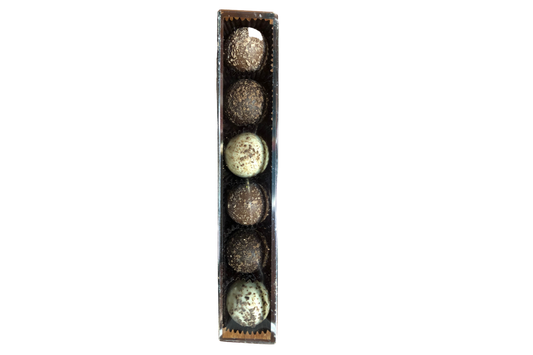 A selection of gourmet chocolate truffles presented in a gift box on a white background