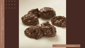 Handmade 72% dark chocolate coconut clusters with toasted coconut flakes, arranged in rustic, bite-sized pieces as a lower-sugar option.