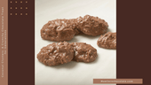 Handmade coconut clusters with toasted coconut flakes coated in milk chocolate, arranged in rustic, shareable pieces.