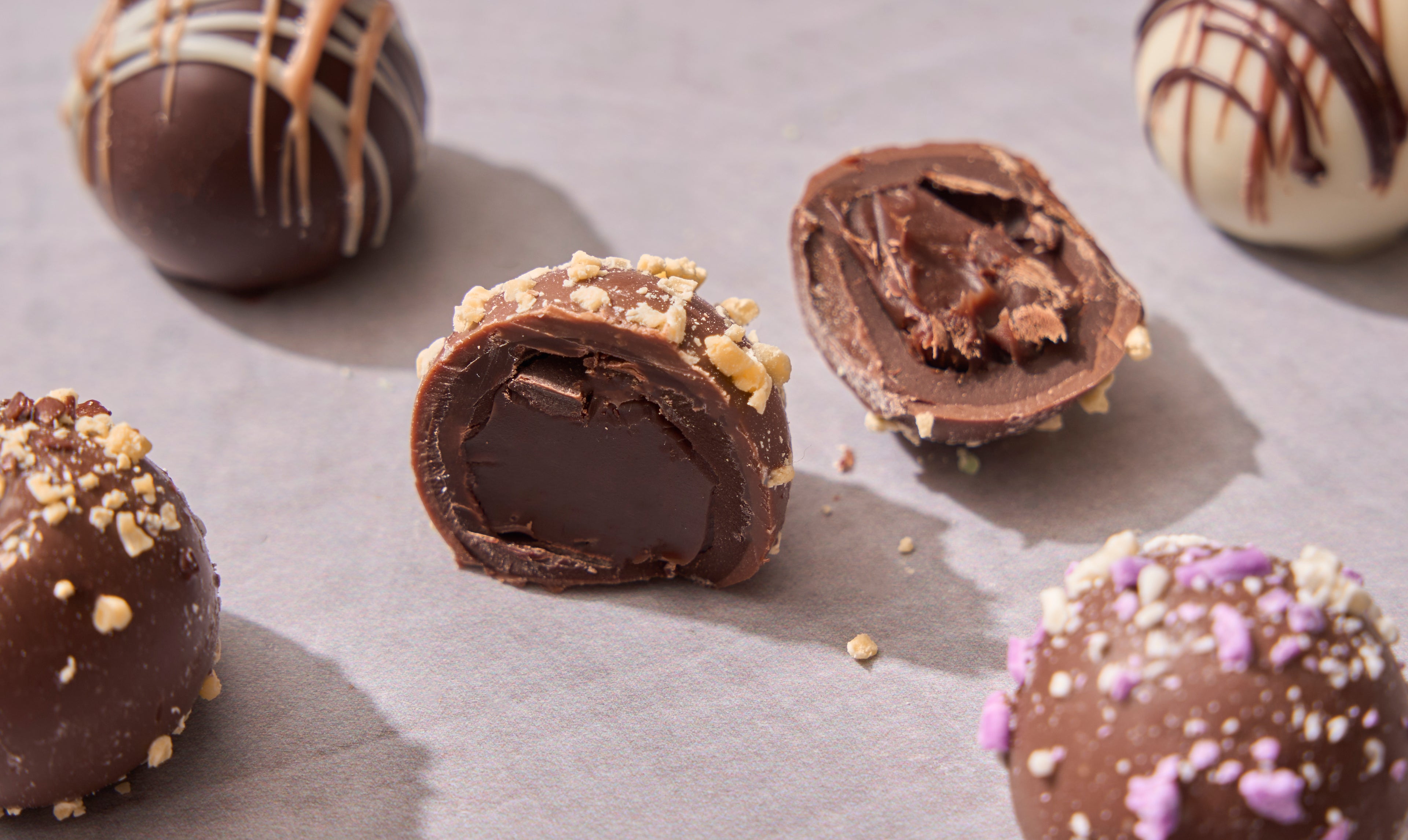 Assorted chocolate truffles with one cut open to show filling